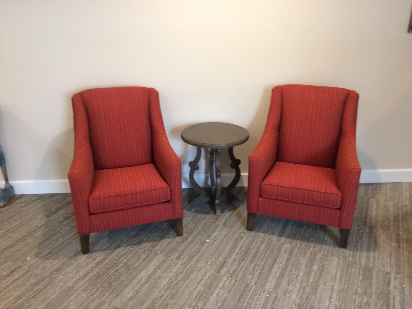 two red chairs with an end table