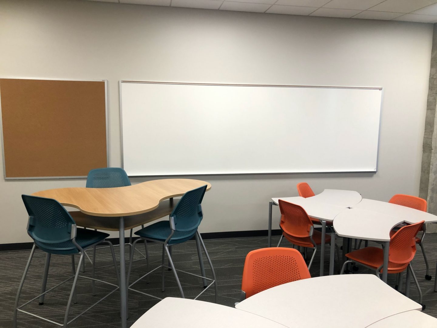 classroom with whiteboard, tables, and chairs