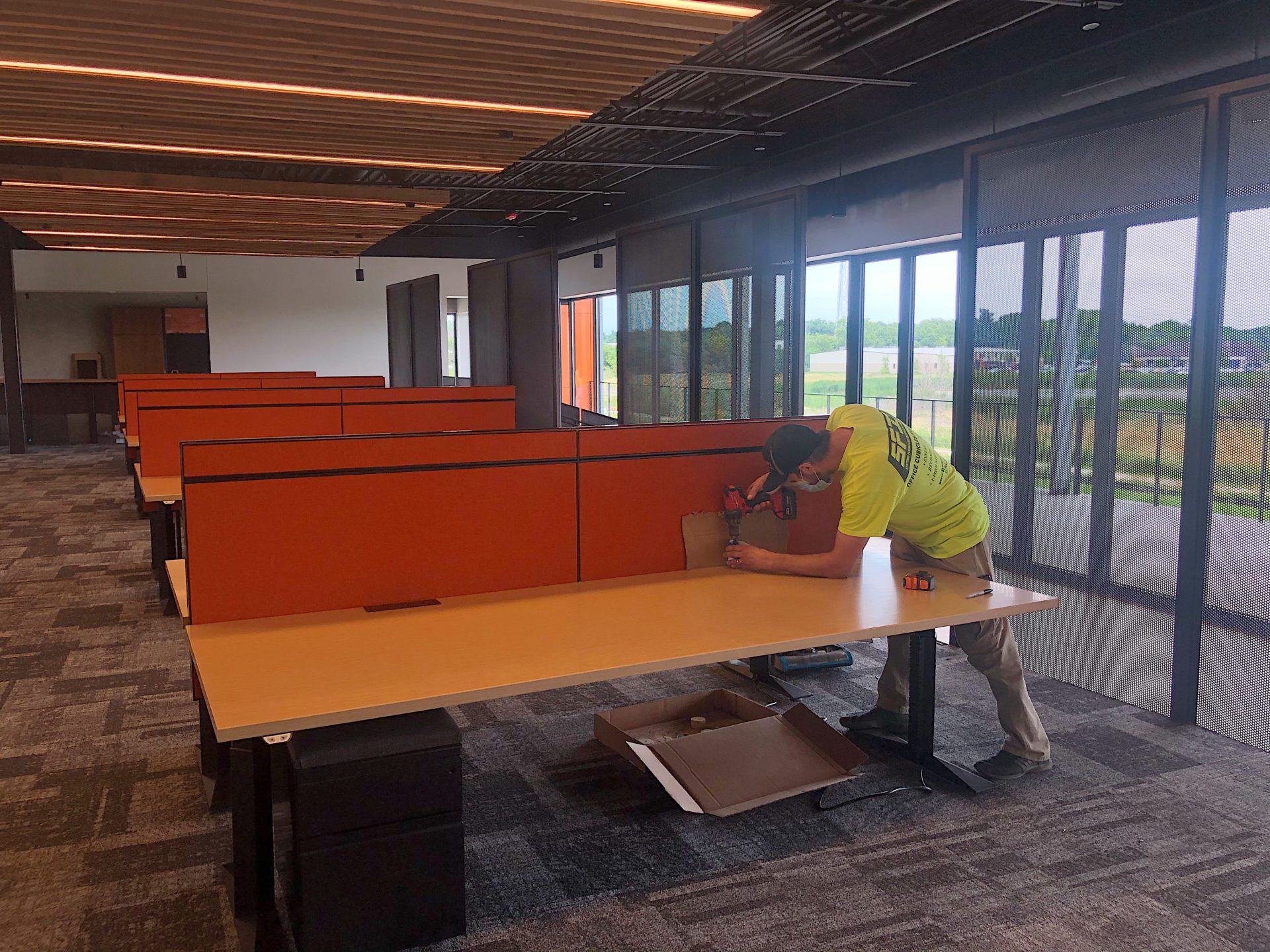 344589BD-3A28-4866-A275-AC6237971757-2143D159-CED2-447A-9592-BFD61E92EC0E worker installing office cubicle walls